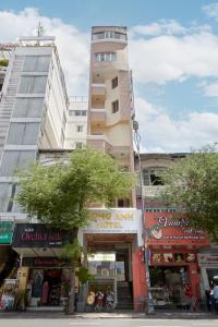 un alto edificio bianco in una strada di città con negozi di Song Anh 1 Hotel ad Ho Chi Minh