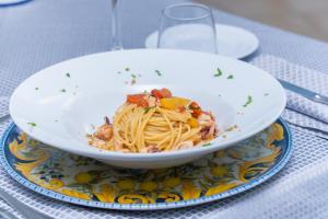 a bowl of pasta on a plate on a table at Hotel America in Marina di Camerota
