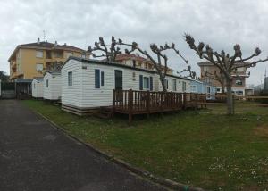 a row of mobile homes parked in a yard at Camping Playa de Ris in Noja