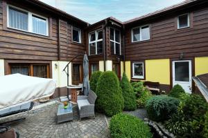 a house with a patio with an umbrella and bushes at Apartmán u Vierky in Veľká Lomnica