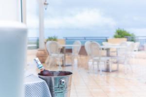 a bucket with a toothbrush in it with a table and chairs at Hotel America in Marina di Camerota