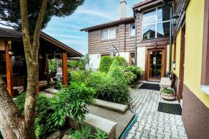 a house with a courtyard with plants and a tree at Apartmán u Vierky in Veľká Lomnica