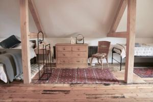 a bedroom with a bed and a dresser and chair at The Post Barn, beautiful barn conversion 10mins from Winchester in Sparsholt