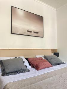 1 cama con 2 almohadas y una foto en la pared en Mavi Apartments, en Dubrovnik