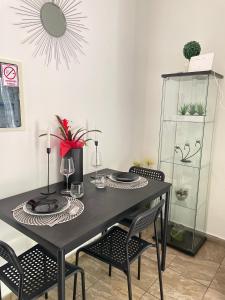 a black dining room table with chairs and a mirror at Mavi Apartments in Dubrovnik