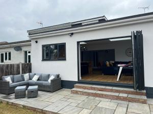 a house with a sliding glass door on a patio at 3 bed luxury open plan living in Rayleigh