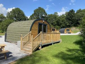 a large wooden cabin with a porch and a deck at Disney Pod 7 Pet Free in Neath