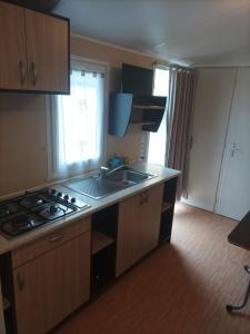 a kitchen with a sink and a stove top oven at Camping Playa de Ris in Noja