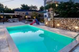 - une piscine avec toboggan rouge à côté d'une maison dans l'établissement Villa ANNA-LENA with pool close to sandy beach, à Garica