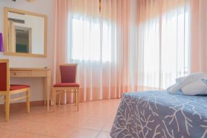 a bedroom with a bed and a desk and a mirror at Hotel America in Marina di Camerota