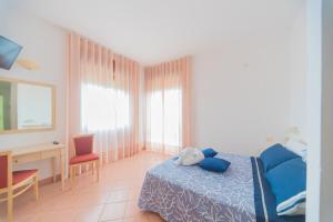 a bedroom with a blue bed and a desk and a desk at Hotel America in Marina di Camerota