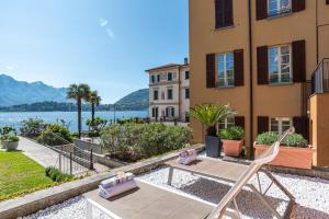 a patio with a table and a chair in front of a building at Maioliche Apartments Griante in Griante Cadenabbia