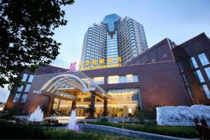a hotel with a fountain in front of a building at Tianjin Saixiang Hotel in Tianjin