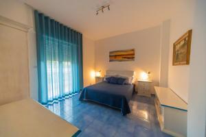 a bedroom with a bed and a large window at Hotel America in Marina di Camerota