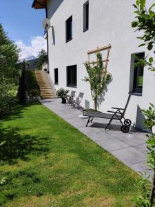 a group of chairs sitting outside of a building at Apartment am Mühlbach in Reith bei Seefeld