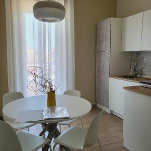 a kitchen with a white table and white chairs at Sole raggiante Lia Darzillo in Afragola