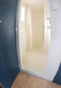 a white bathroom with a white shower backdoor at Camping Playa de Ris in Noja