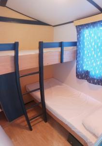 a room with two bunk beds and a chair at Camping Playa de Ris in Noja