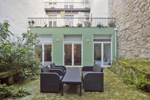 un patio avec des chaises et une table devant un bâtiment dans l'établissement Citybreak-apartments Bolhao, à Porto