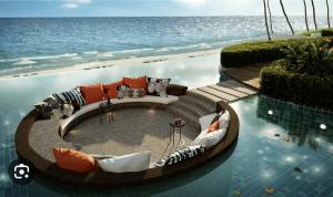 a swimming pool with chairs and the ocean in the background at Timurbay seafront residence in Kuantan