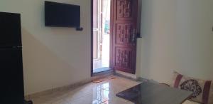 um quarto com uma porta, uma mesa e uma televisão em APARTAMENTOS NASSIRi em El Aiune