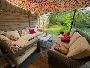 a screened in porch with two couches and a table at La Chambre Du Voyageur in Soustons