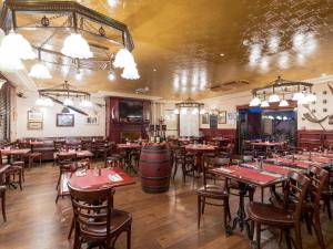 a restaurant with tables and chairs and a wine barrel at Le Celtic in Le Thillay