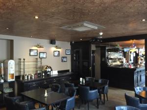 restauracja ze stołami i krzesłami oraz bar w obiekcie Le Celtic w mieście Le Thillay