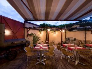 een restaurant met tafels en stoelen op een terras bij Le Celtic in Le Thillay