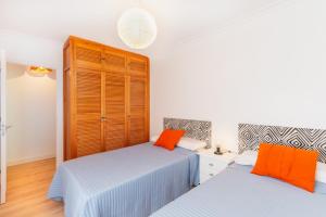 a bedroom with two beds and a closet at Las Olas Chipiona in Chipiona