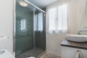 een badkamer met een glazen douche en een wastafel bij Las Olas Chipiona in Chipiona