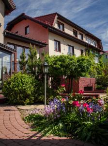 ein Haus mit einem Garten mit Blumen davor in der Unterkunft Akme APARTMENTS&ROOMS in Danzig