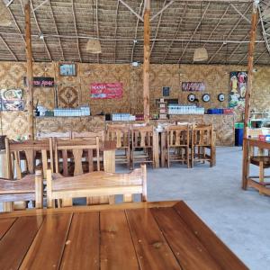 een eetkamer met houten tafels en banken bij 777 Beach Condo Phuket in Mai Khao Beach