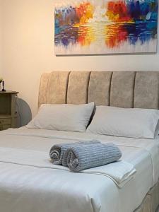 a blanket on a bed with a painting on the wall at Nice Studio Unit at Tiara Imperio Bangi in Kajang