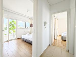 a white bedroom with two beds and a window at Menelaou by Verde Apartments in Athens