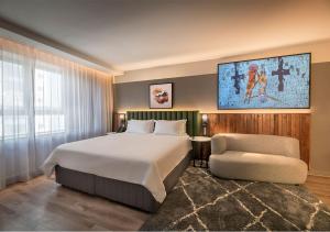 1 dormitorio con 1 cama grande y 1 silla en The Rockefeller Hotel by NEWMARK, en Ciudad del Cabo