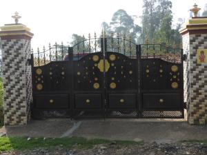 a black gate with gold decorations on it at Shanthi Villa in Coonoor
