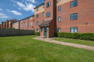 a brick building with a green door in a yard at 2 bed luxury apartment in Enfield