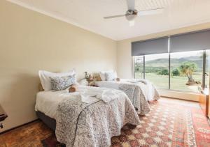1 Schlafzimmer mit 2 Betten und einem großen Fenster in der Unterkunft Nkomazi Game Reserve by NEWMARK in Badplaas
