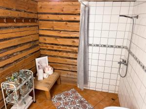 a bathroom with a wooden accent wall and a shower at Merela guest house in Võsu centre in Võsu