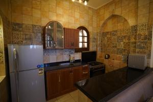 a kitchen with a refrigerator and a counter top at Tunis castle in ‘Izbat an Nāmūs