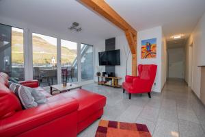 a living room with a red couch and a red chair at Ferienwohnung Cella in Zell an der Mosel