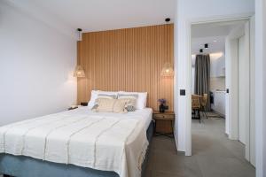 a bedroom with a large white bed and a hallway at Milatos Seaside Suites in Milatos