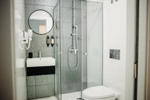 a bathroom with a shower and a toilet and a sink at Next Level Premium Hotels in Lisbon