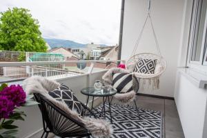 a balcony with two chairs and a table and a window at City-House-Achern in Achern