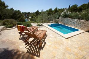 two deck chairs and a swimming pool in a yard at Villa Alexandria in Milna