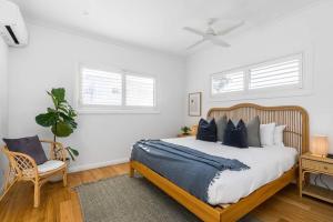 um quarto com uma cama grande e almofadas azuis em Villa Wallah Luxury in Byron Bay em Byron Bay