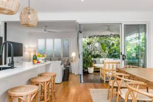 a kitchen and living room with a table and chairs at Villa Wallah Luxury in Byron Bay in Byron Bay