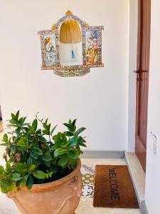 een plant in een pot naast een muur bij B&B L'Agapanto in Capri