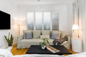 uma sala de estar com um sofá e uma mesa em Villa Wallah Luxury in Byron Bay em Byron Bay